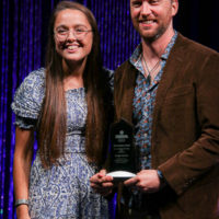 Tabitha Benedict with George Jackson and his 2022 IBMA Momentum Instrumentalist award - photo © Frank Baker