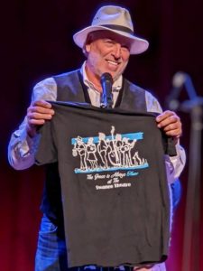 Ken Lingafelt shows off the t-shirt they designed to promote bluegrass at The Swanee Theatre in Kannapolis, NC - photo by Vivian Pennington Hopkins