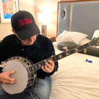 Carl Jackson checks out his new Recording King signature model banjo at SPBGMA 2023 - photo by Robin Jackson