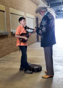 Doyle Lawson gives an impromptu lesson to a young mandolinist at the 2019 Yeehaw Music Fest - photo by Tom Schuveiller