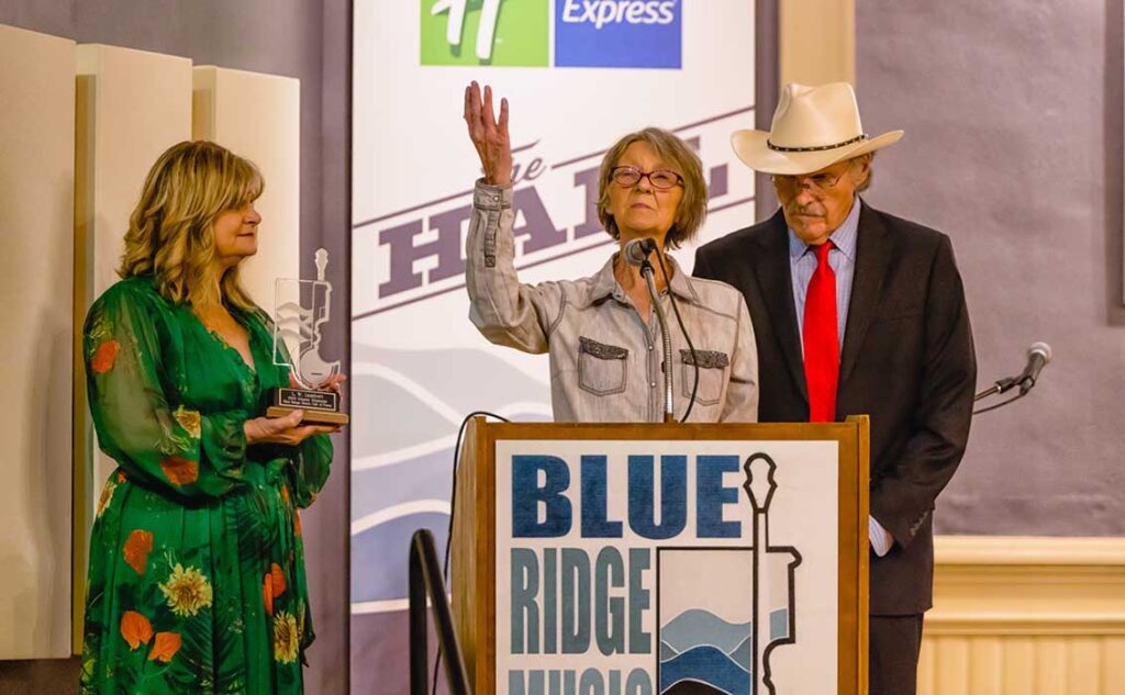 Melisa Cornett accepts for her father, L.W. Lambert, at the 2023 Blue Ridge Music Hall of Fame induction ceremony, with Cindy and Terry Baucom - photo by Monty and Brenda Combs