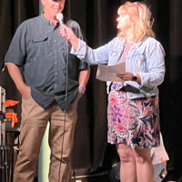 Cindy Baucom speaks with festival coordinator Cody Johnson the first Tony Rice Memorial Day Musicfest (5/19/23) - photo by Gary Hatley