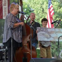 Lori Lambert presents a check to Dante Flores at the 2023 Charlotte Bluegrass Festival - photo © Bill Warren