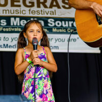 Evelyne Pitney sings with her mom and dad at the 2023 Cherokee Bluegrass Festival - photo © Laci Mack