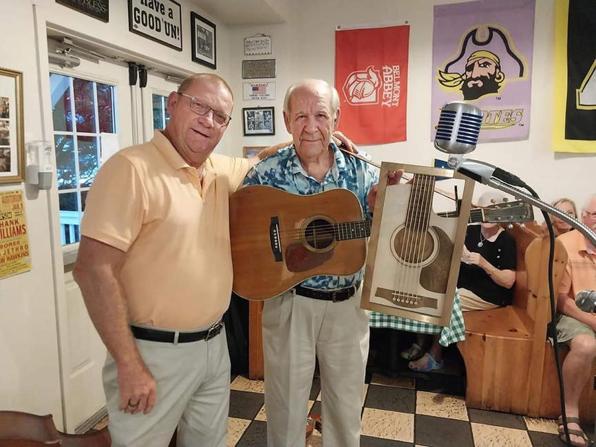 Carroll Haire with his son, Eddie, and the plaque he was given by his bandmates