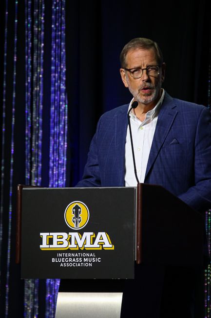 Outgoing IBMA Executive Director Ken White speaks at the 2023 World of Bluegrass - photo © Frank Baker
