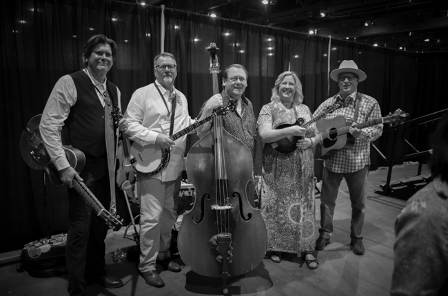 Wally Hughes, Clyde Bailey, Joe Hannabach, Lisa Kay Howard Hughes, and unknown guitarist in the Exhibit Hall at IBMA Bluegrass Live! (9/30/23) - photo © Jeromie Stephens