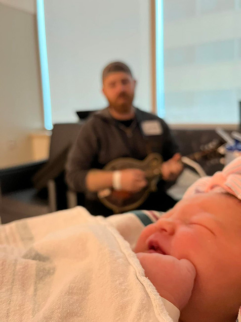 Kevin Strouth serenades his newborn daughter, Amelia, in the hospital