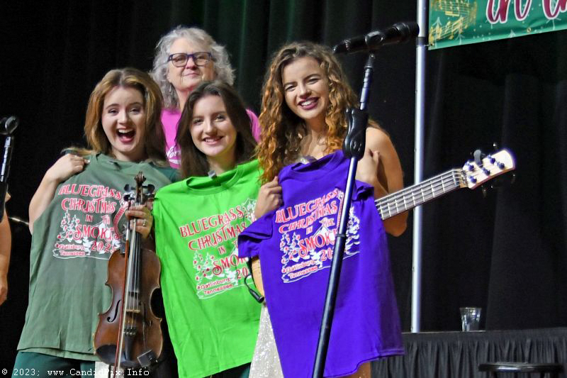Lorraine Jordan and the Williamson girls show of festival merch at the 2023 Bluegrass Christmas in the Smokies - photo © Bill Warren