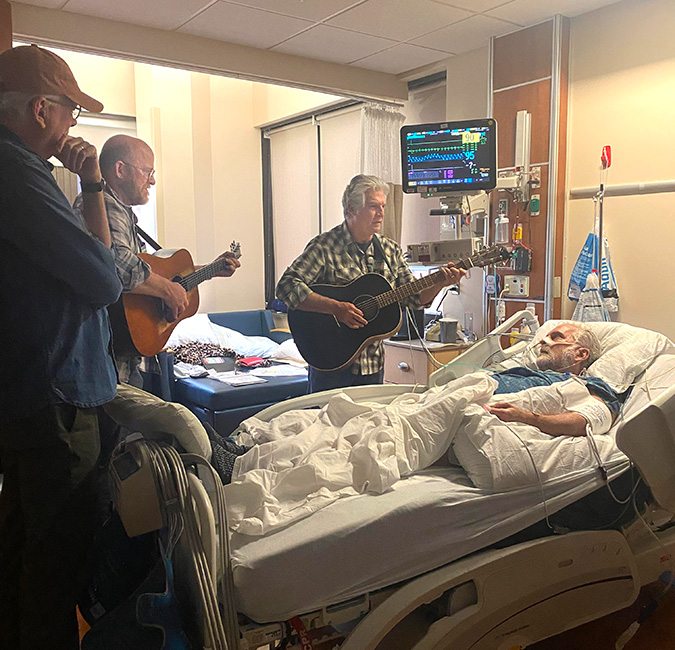 Bob Minner, Jerry Salley, and Byron Hill share some music with Glen Duncan in the hospital while he recovers from a stroke