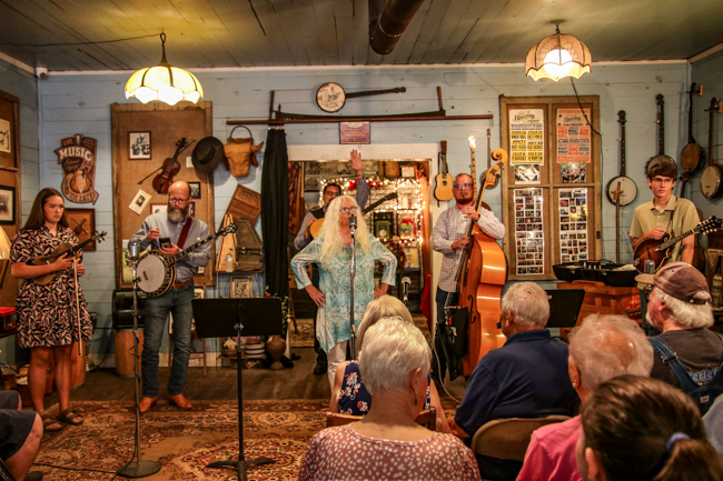 Vivian Pennington Hopkins introduces Greg Blake and fellow musicians at the house concert at the E.H. Montgomery General Store in Gold Hill, NC - photo © G Nicholas Hancock