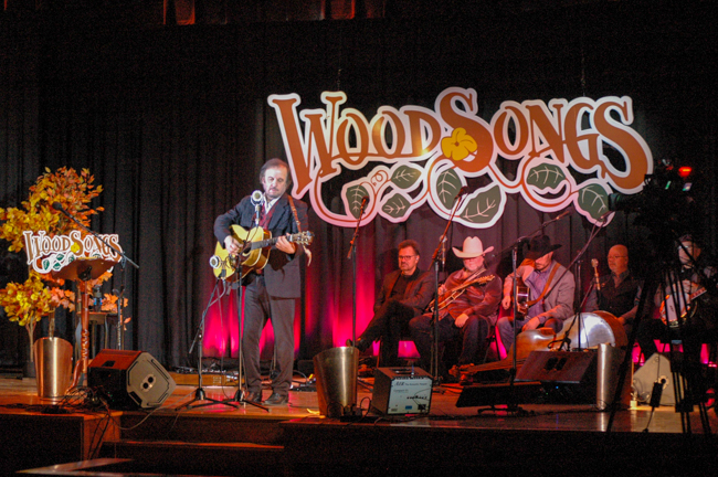 Host Michael Jonathan performs while Southern Legacy waits to go on at WoodSongs Old Time Radio Hour (2/9/26) - photo © Roger Black