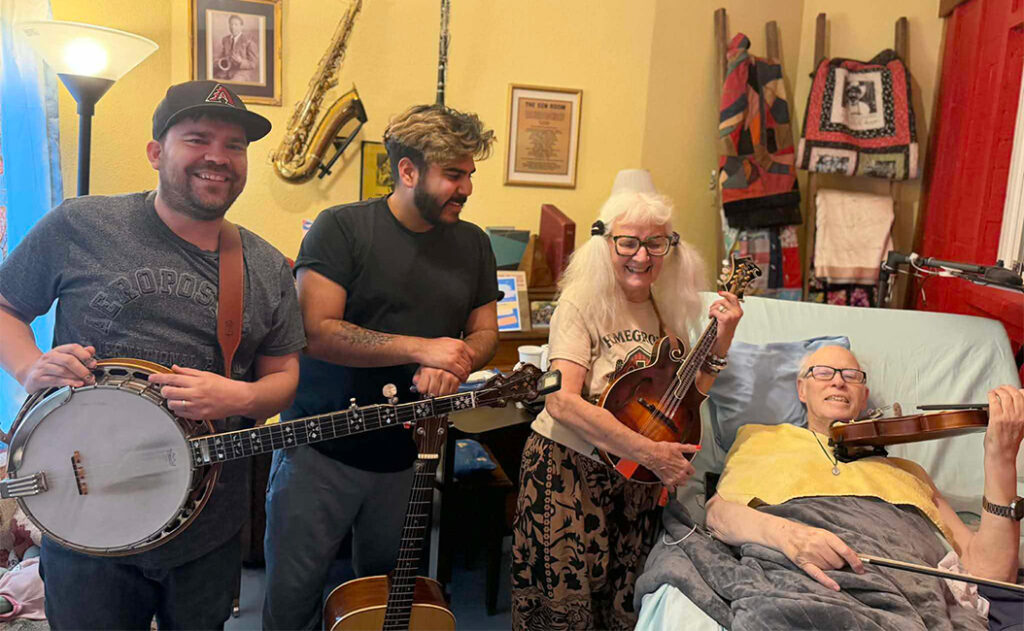 Howard with his fiddle in hospice, with Anni Beach on mandolin, and a couple of Jam Pack students