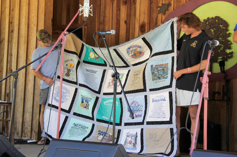 Promoter Mike Wilson receives a custom quilt from his family at the 2026 Willow Oak Bluegrass Festival - photo © Laura Ridge