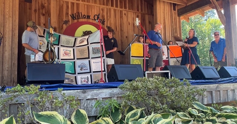 T-shirt quilts are presented to Mike Wilson by his family at the final Willow Oak festival - photo © Sandy Hatley