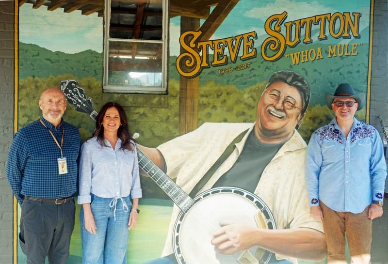 Lee Rose, Alecia Nugent, and Darren Nicholson with a mural of Steve Sutton at the 2026 Steve Sutton Fest - photo © Jeff Lahr