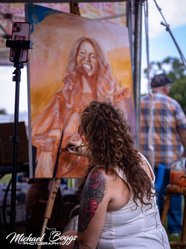 Haley Elizabeth Boys paints Hannah Harper during her set at Rudy Fest 2026 - photo © Michael Boggs