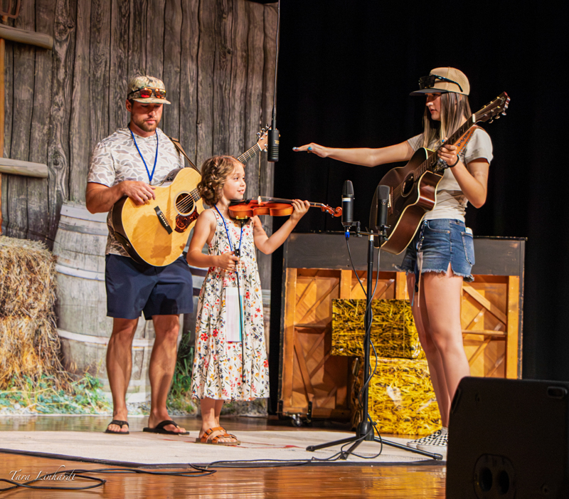 Adjusting the mic for a Small Fry Contestant  at the 2026 National Oldtime Fiddlers' Contest & Festival - photo © Tara Linhardt