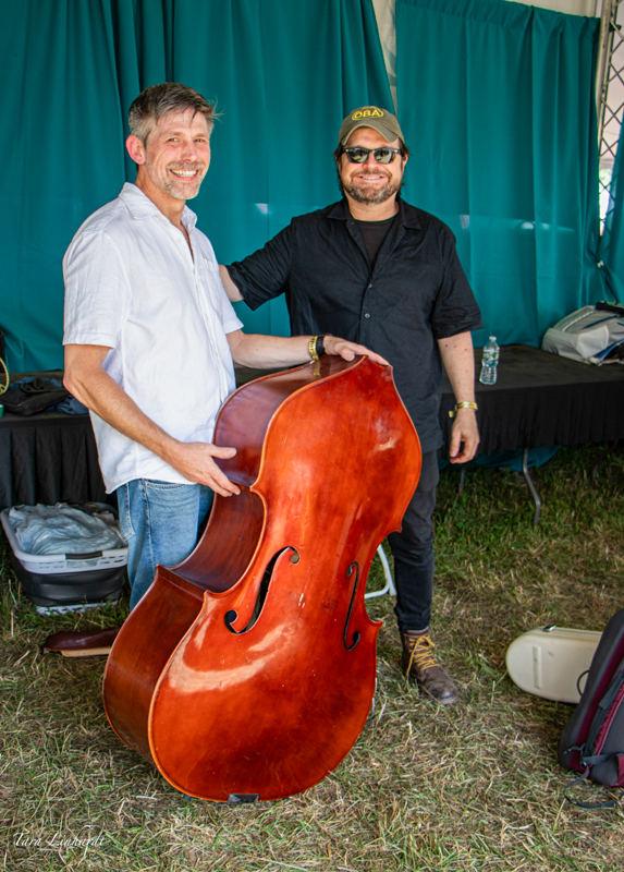  Konrad Liddy from I Draw Slow folding up his bass after the show, alongside Dave Holden at the 2026 Grey Fox Bluegrass Festival - photo © Tara Linhardt