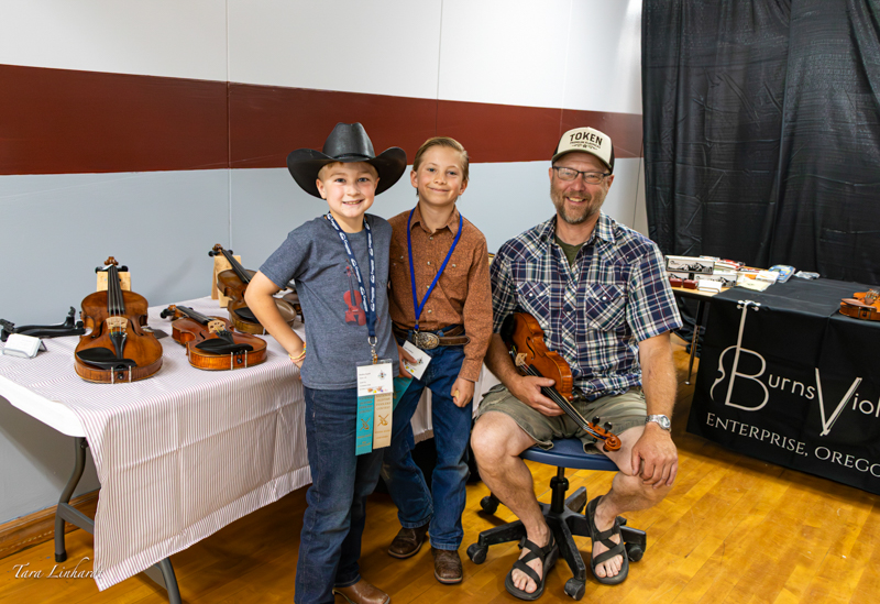 Luthier Mike Barns with two young contestants at the 2026 National Oldtime Fiddlers' Contest & Festival - photo © Tara Linhardt