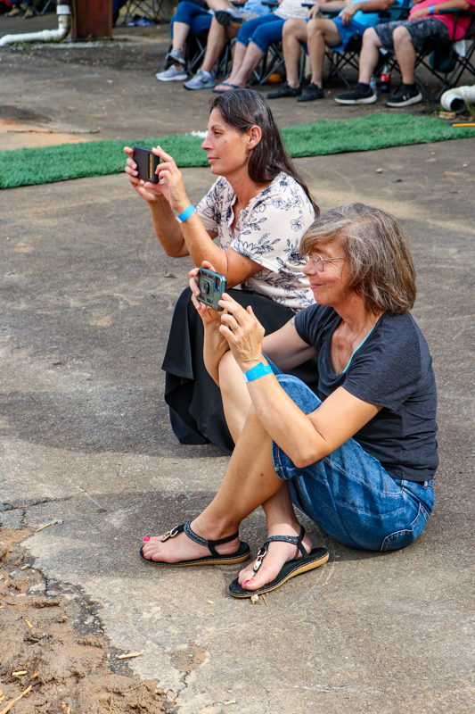 Rebekah Walls and Katrin Rippel video their sons onstage at the 2026 Alleghany County Fiddlers' Convention - photo © G. Nicholas Hancock