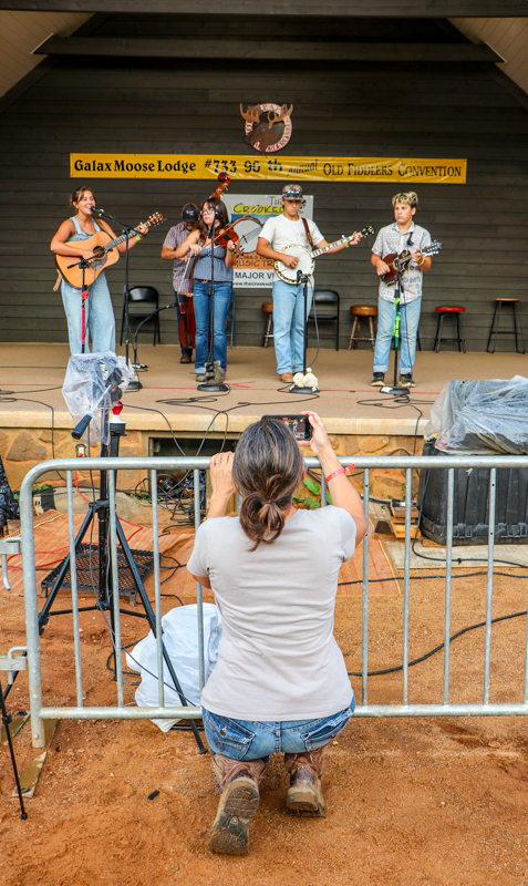 Cerisa Trakimowicz videoing Dear MariBella & The Pigkickers at the 2026 Old Fiddlers’ Convention – photo © G. Nicholas Hancock
