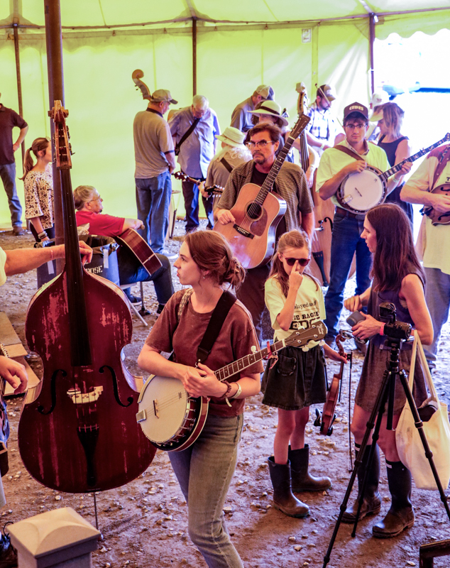 Different band members waiting in line under the big yellow tent at the 2026 Old Fiddlers’ Convention – photo © G. Nicholas Hancock