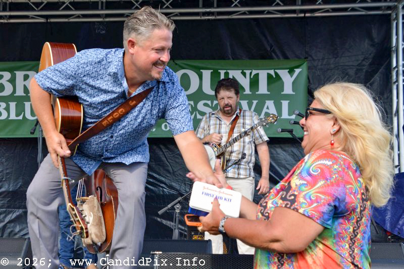Jeremie Cole with Harbourtown offers Ami Ricci a first aid kit at the 2026 Brown County Bluegrass Festival - photo © Bill Warren