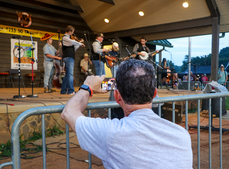 Ed Oakes videoing The Big Ridge Ramblers at the 2026 Old Fiddlers’ Convention – photo © G. Nicholas Hancock