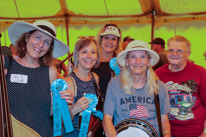 Happy participants under the big yellow tent at the 2026 Old Fiddlers’ Convention – photo © G. Nicholas Hancock