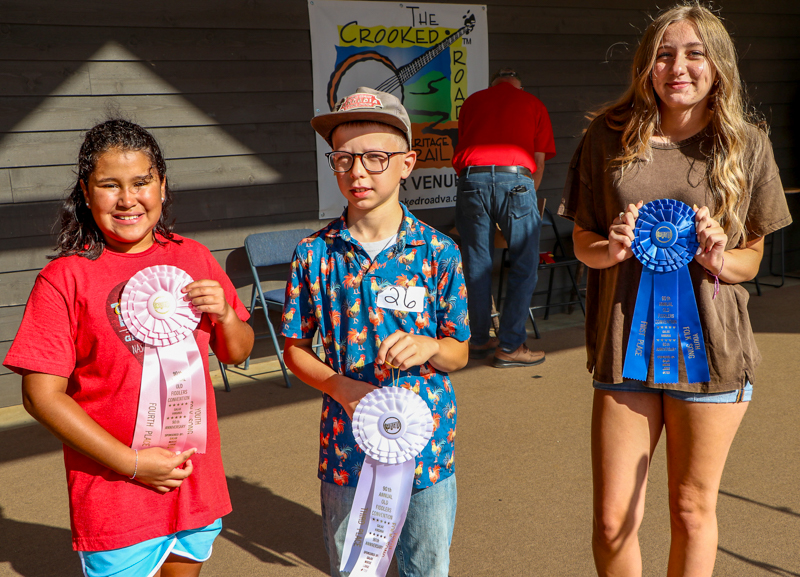 Maylyn Todd, 4th place; Leo Lindblom, 3rd place; and Jasie Slaughter, 1st place in Youth Folksong at the 2026 Old Fiddlers’ Convention – photo © G Nicholas Hancock