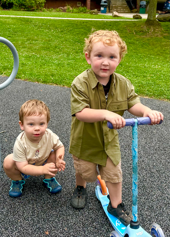Andrew II had a great time making the rounds on a scooter and playing with his new little bluegrass buddy, John Merle Wood at his grandpa's 80th birthday celebration (7/26/26) - photo © Karen Artis