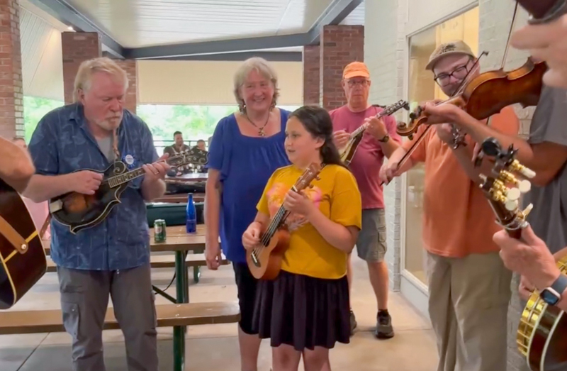 Sweet 10-year-old granddaughter Libby, playing ukulele with Grampa & Gramma in her first jam session ever at Bob Artis' 80th birthday celebration (7/26/26) - photo © Karen Artis