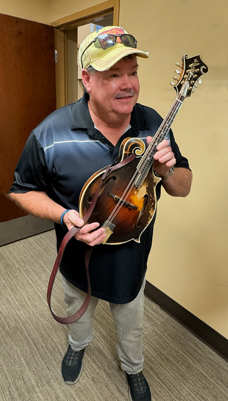 Tim Moon running off with Lorraine Jordan's mandolin at Zoograss 2026 - photo © Lorraine Jordan
