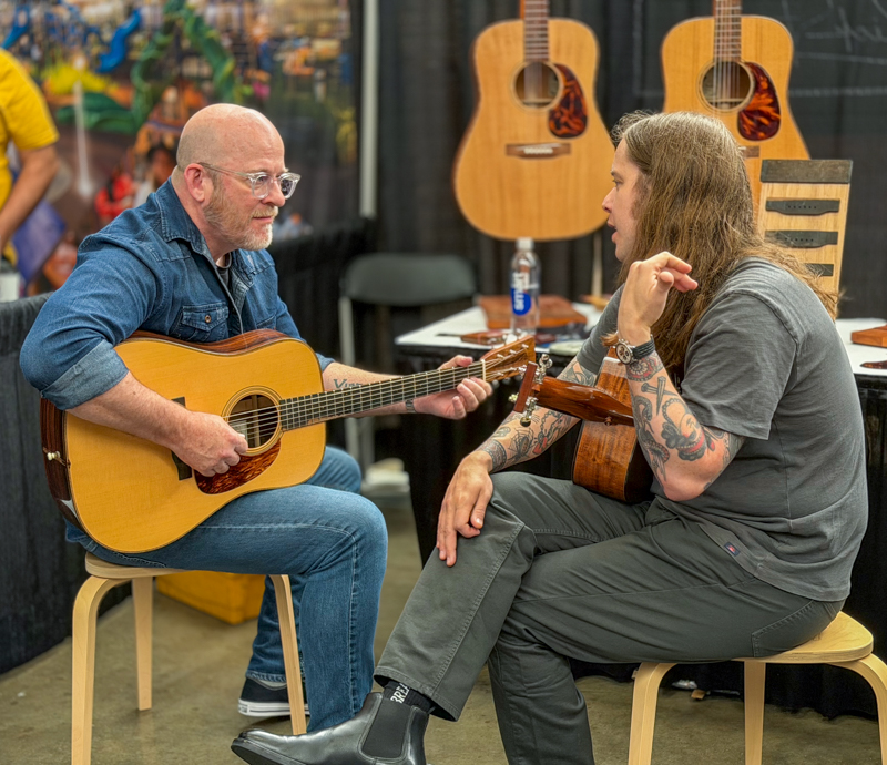 Bob Minner and Billy Strings trading licks in the World of Bluegrass Exhibit Hall - photo © Elizabeth Loring