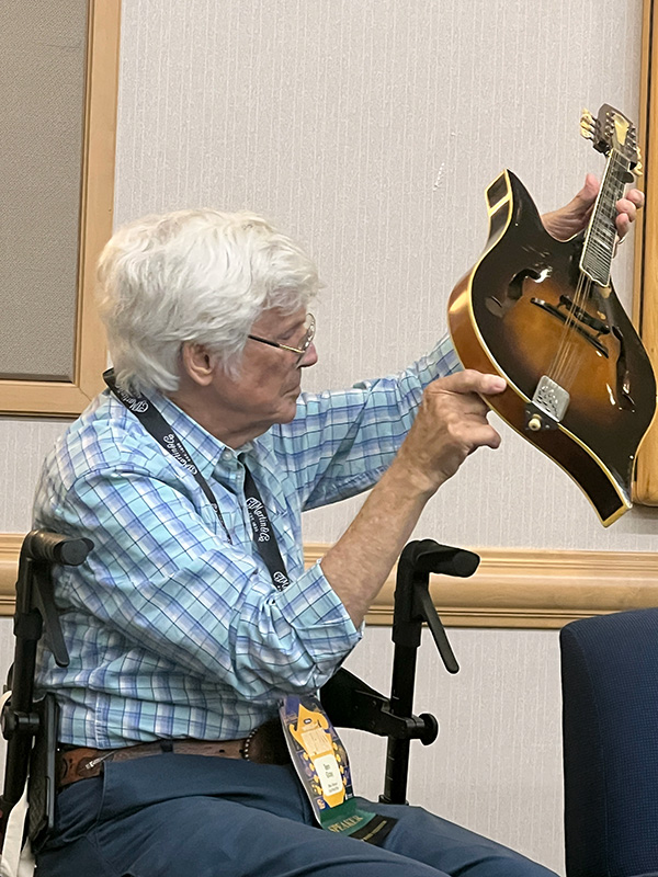 Tom Gray shows off John Duffey's iconic Duck mandolin at World of Bluegrass 2026 - photo © Sandy Hatley