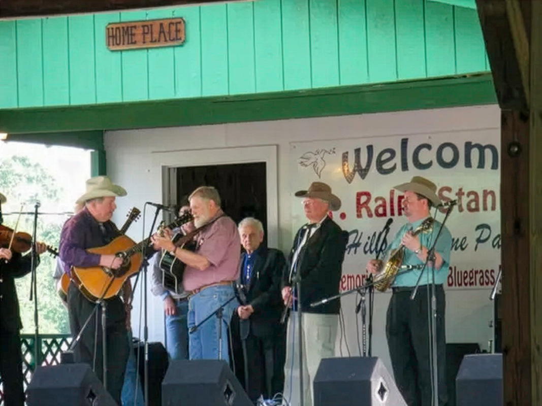 Rickey Lee being presented with a guitar by Ralph Stanley at the Hills of Home festival in 2021